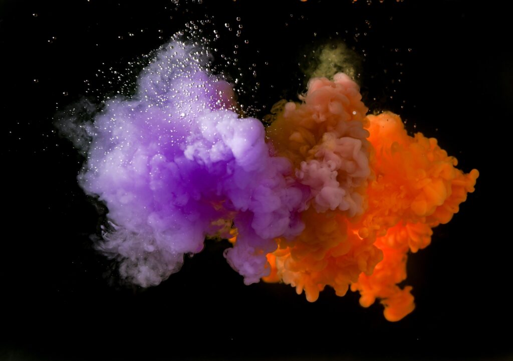 Photo of orange and purple smoke converging