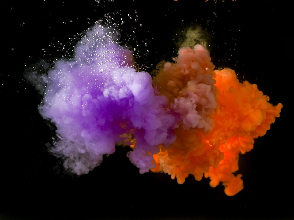 Photo of orange and purple smoke converging